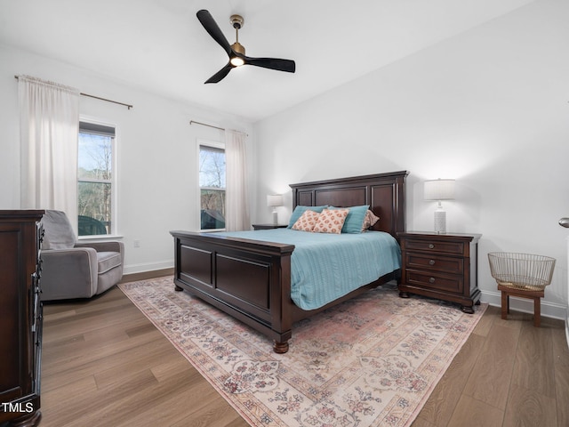 bedroom featuring light wood-style floors, baseboards, and a ceiling fan