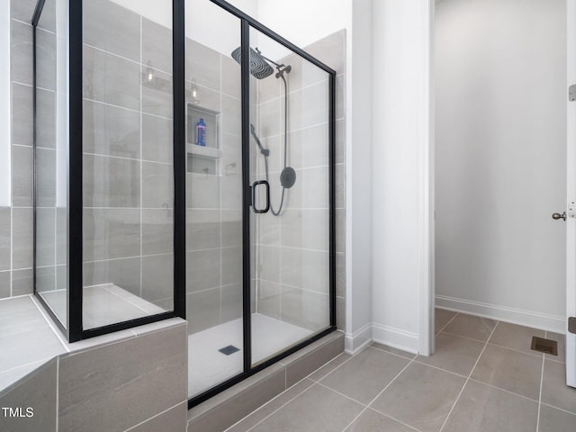 bathroom featuring a stall shower, baseboards, and tile patterned floors