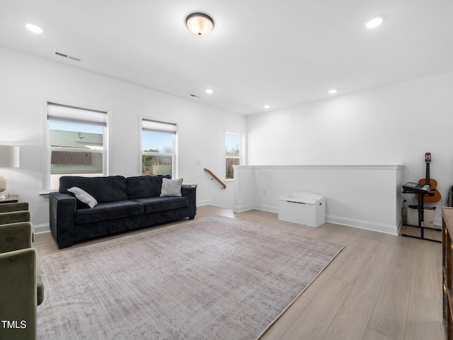 living room featuring light wood-style floors, recessed lighting, visible vents, and baseboards