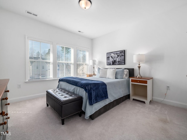 bedroom with baseboards, visible vents, and light colored carpet