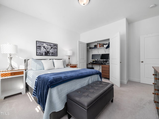 bedroom featuring baseboards, a closet, and light colored carpet