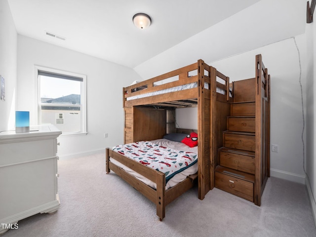 bedroom with light colored carpet, visible vents, vaulted ceiling, and baseboards