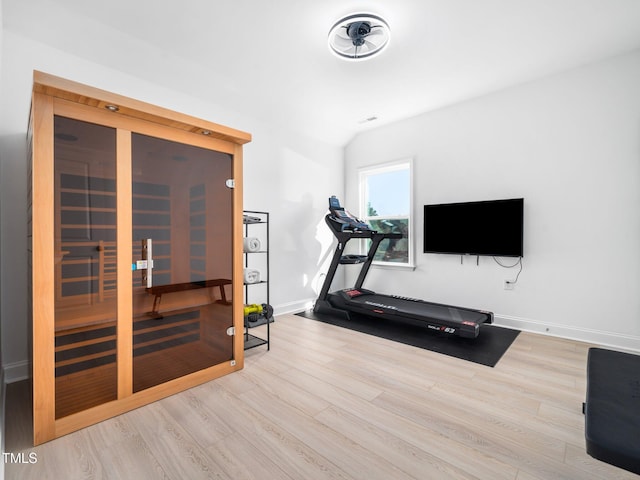 exercise area with a sauna, baseboards, and wood finished floors