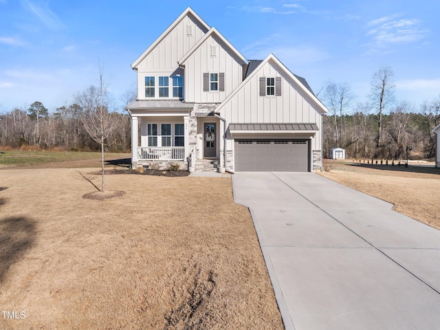 modern farmhouse featuring driveway, a garage, covered porch, a standing seam roof, and board and batten siding