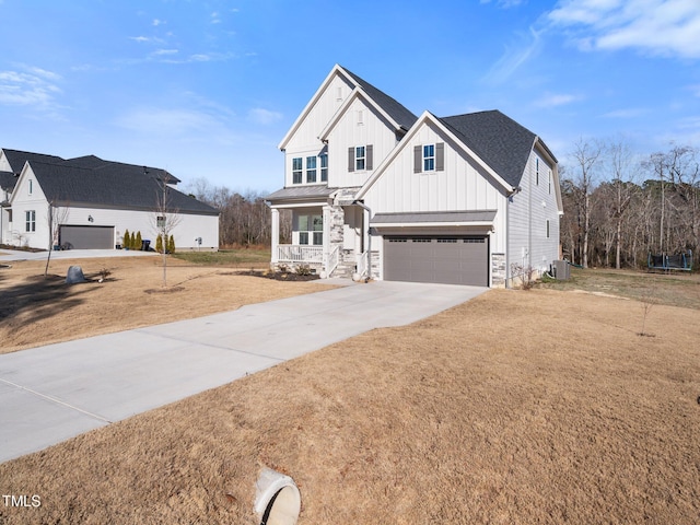 view of front facade with an attached garage, central air condition unit, concrete driveway, stone siding, and board and batten siding