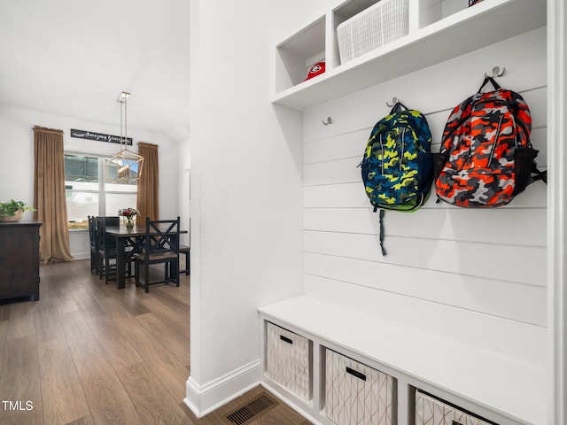 mudroom with baseboards, visible vents, and wood finished floors