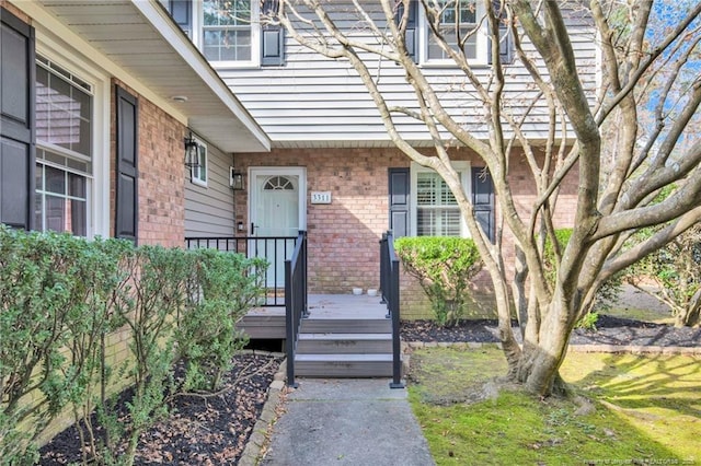 view of exterior entry with brick siding