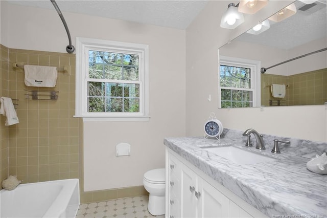 bathroom with baseboards, toilet, tub / shower combination, a textured ceiling, and vanity