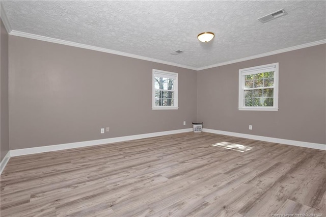 unfurnished room with crown molding, visible vents, and wood finished floors