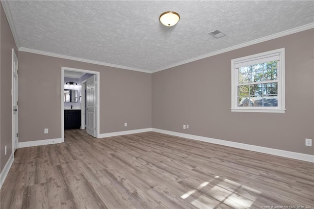 interior space with crown molding, wood finished floors, visible vents, and baseboards