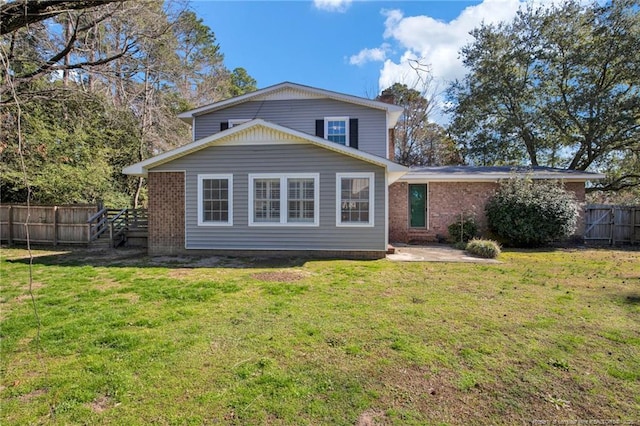 back of house with a yard, a patio area, fence, and brick siding