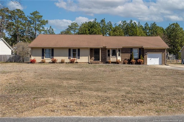 ranch-style house featuring a garage, fence, and brick siding