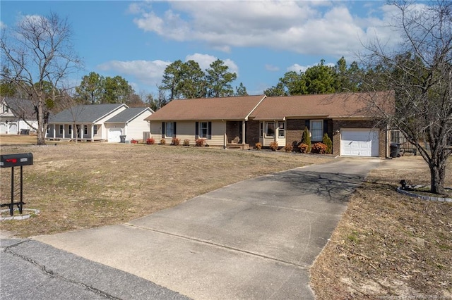 ranch-style home with a garage, driveway, a front lawn, and brick siding