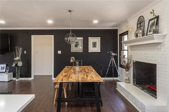 dining room featuring crown molding, dark wood-style flooring, a brick fireplace, and baseboards