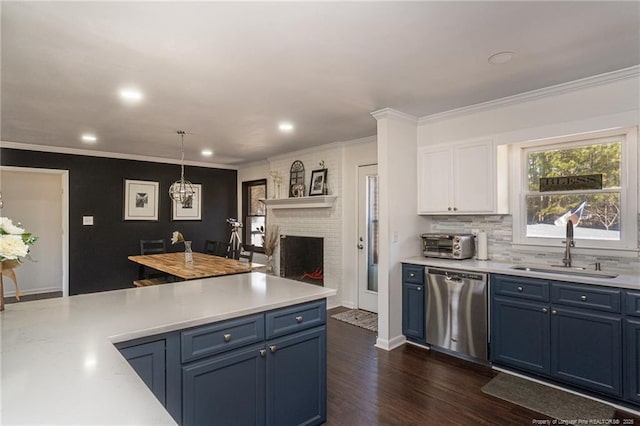 kitchen featuring a sink, blue cabinetry, light countertops, and stainless steel dishwasher