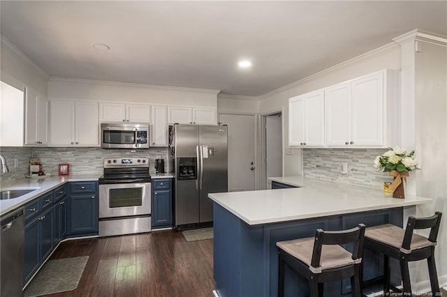 kitchen featuring stainless steel appliances, white cabinets, blue cabinets, and a sink