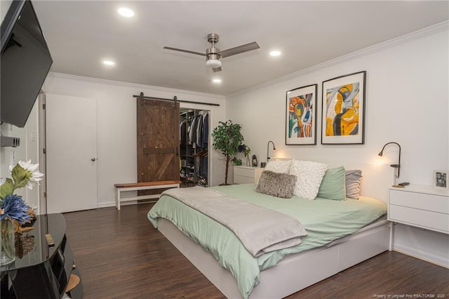 bedroom with recessed lighting, a closet, a barn door, ornamental molding, and wood finished floors