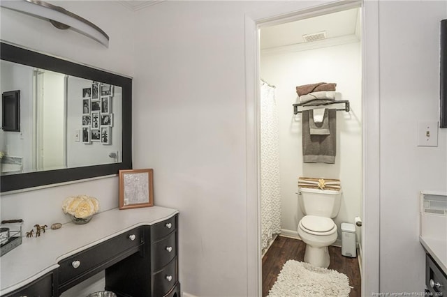 full bathroom featuring crown molding, visible vents, toilet, vanity, and wood finished floors