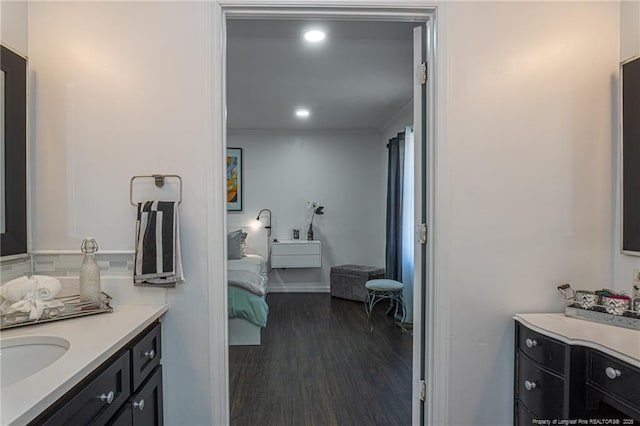 ensuite bathroom featuring recessed lighting, connected bathroom, vanity, and wood finished floors