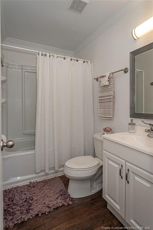 bathroom with visible vents, toilet, wood finished floors, crown molding, and vanity