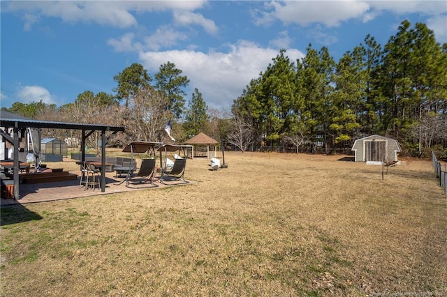 view of yard with an outdoor structure, a shed, a gazebo, and fence