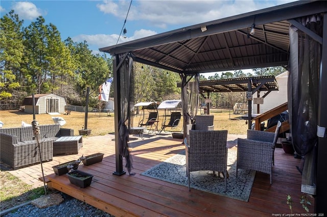 wooden deck featuring an outbuilding, a gazebo, and a storage unit