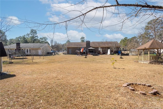 view of yard with a gazebo, a trampoline, and fence