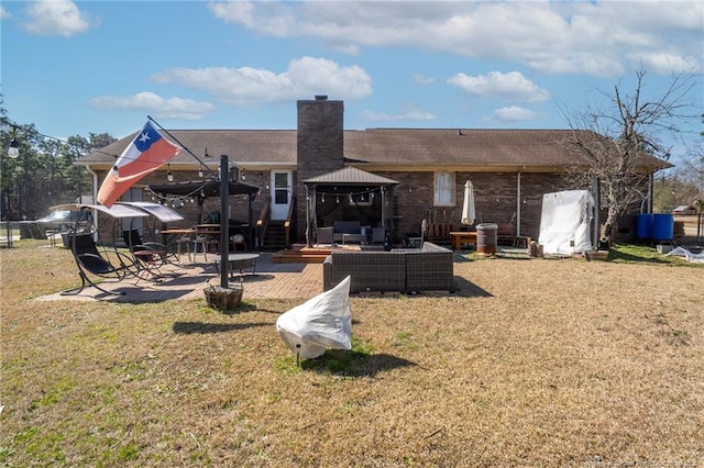 rear view of house featuring brick siding, a chimney, a lawn, a patio area, and an outdoor living space