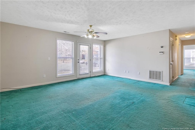 empty room with baseboards, carpet, visible vents, and a textured ceiling