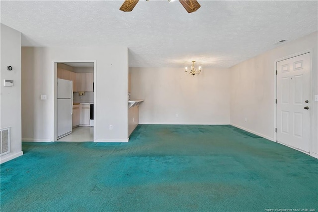 unfurnished living room with light carpet, a textured ceiling, ceiling fan with notable chandelier, and visible vents