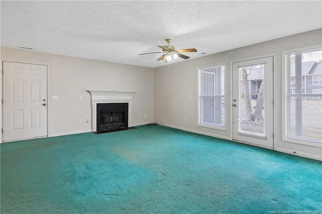 unfurnished living room with a textured ceiling, carpet floors, a fireplace with flush hearth, and baseboards