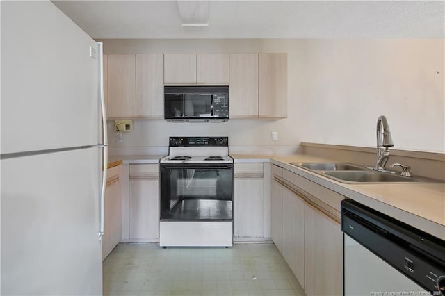 kitchen featuring white appliances, a sink, light countertops, light brown cabinetry, and light floors