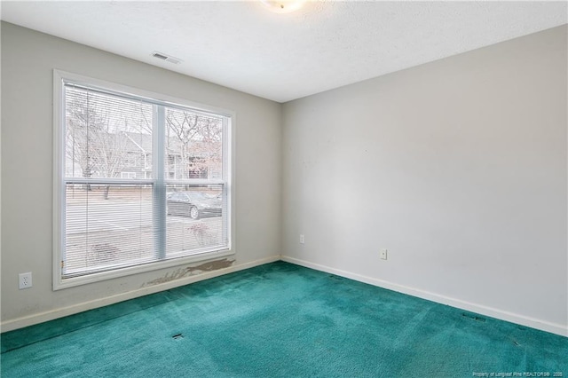 spare room featuring carpet floors, baseboards, and visible vents