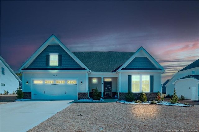 craftsman-style house with an attached garage, concrete driveway, and brick siding