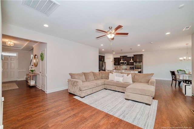 living area featuring recessed lighting, visible vents, baseboards, and wood finished floors