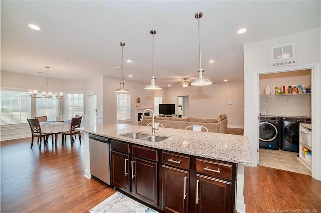 kitchen featuring visible vents, dishwasher, independent washer and dryer, light wood-type flooring, and a sink