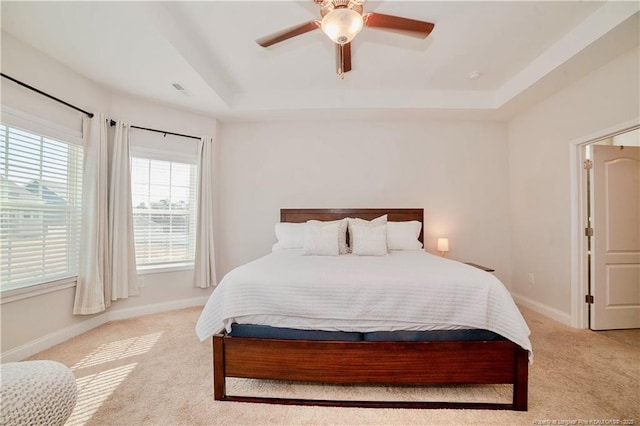 bedroom featuring carpet, a raised ceiling, a ceiling fan, and baseboards