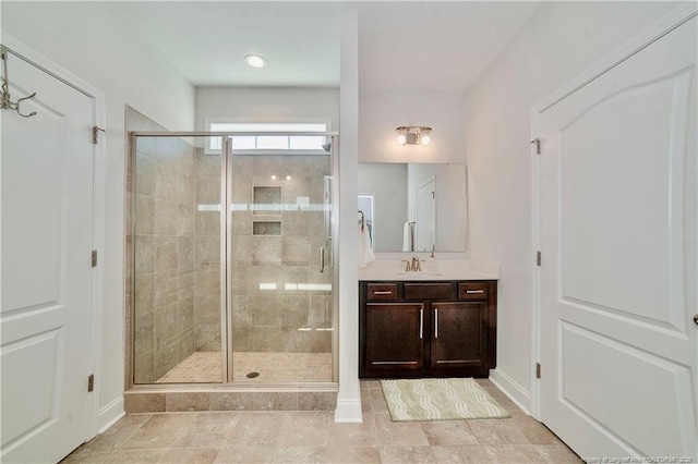 bathroom featuring a shower stall, baseboards, and vanity