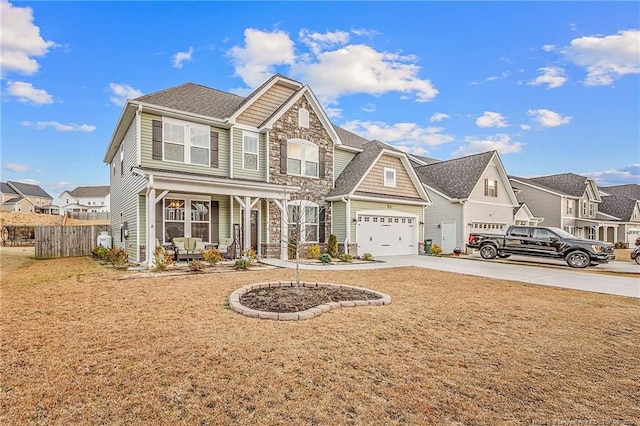 view of front facade with covered porch, concrete driveway, a garage, a residential view, and stone siding