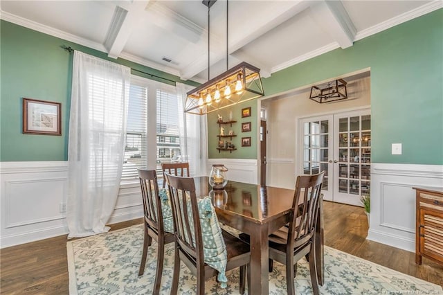 dining room with coffered ceiling, wainscoting, dark wood-style flooring, french doors, and beam ceiling