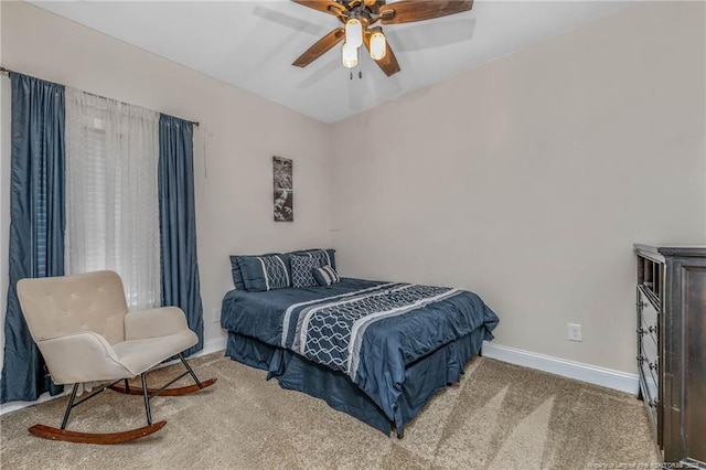 carpeted bedroom featuring baseboards and a ceiling fan