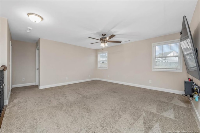 spare room featuring carpet floors, ceiling fan, and baseboards