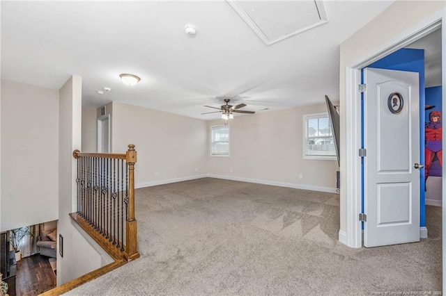 carpeted spare room featuring ceiling fan and baseboards