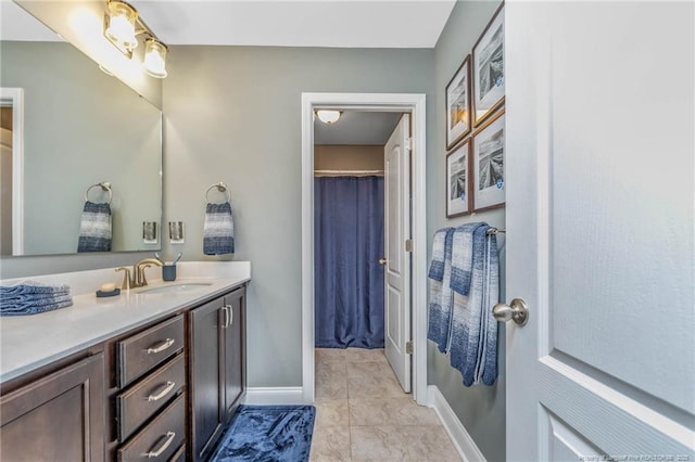 bathroom with tile patterned flooring, a shower with curtain, vanity, and baseboards