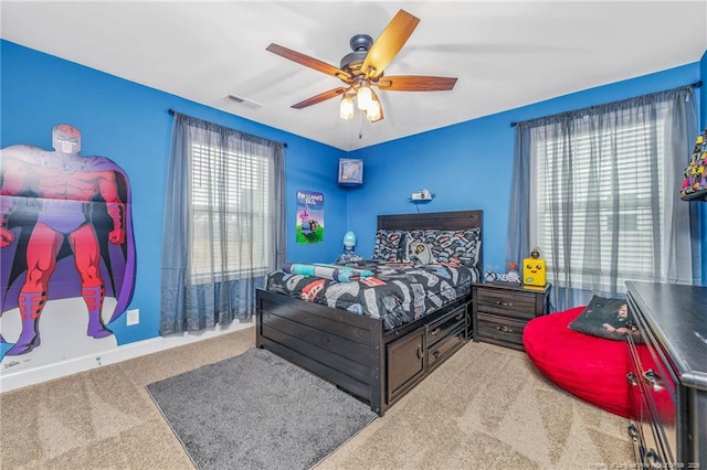 carpeted bedroom with a ceiling fan, visible vents, and baseboards