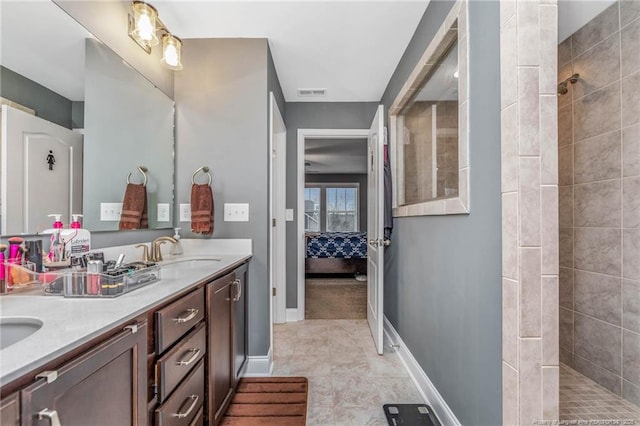 ensuite bathroom with double vanity, visible vents, ensuite bathroom, a sink, and walk in shower