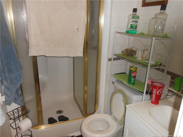 bathroom with vanity, a shower stall, and toilet