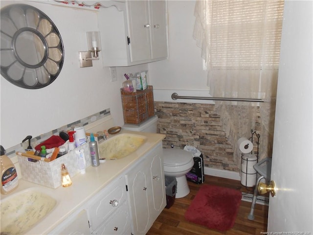 bathroom with vanity, toilet, and wood finished floors