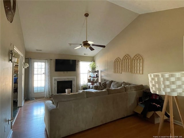 living room featuring plenty of natural light, a fireplace, lofted ceiling, and wood finished floors