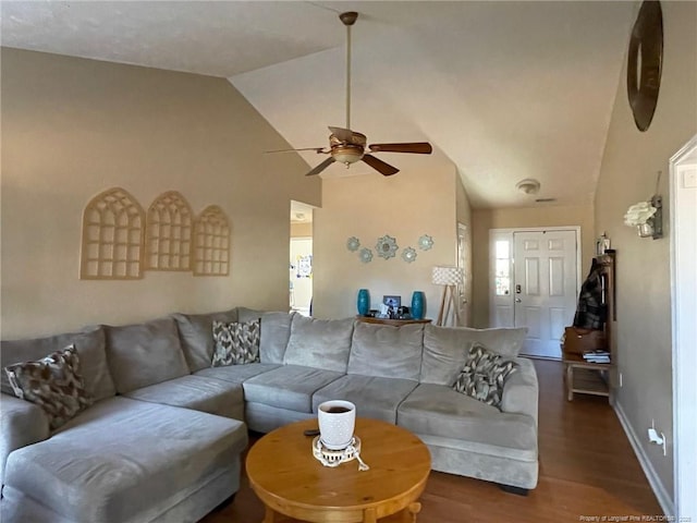 living area featuring a ceiling fan, baseboards, vaulted ceiling, and wood finished floors